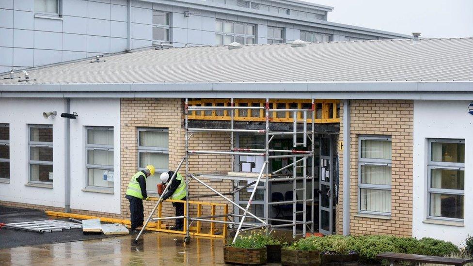 Workers on site at one of the closed schools