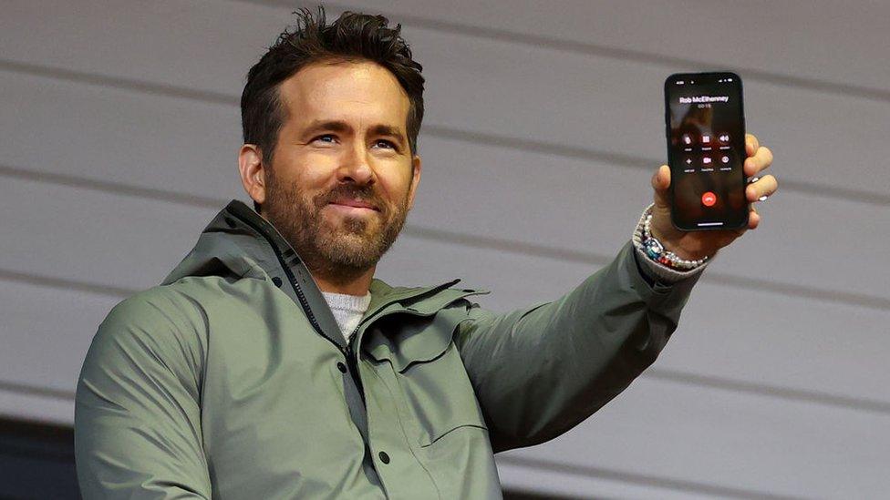 Reynolds holding a phone