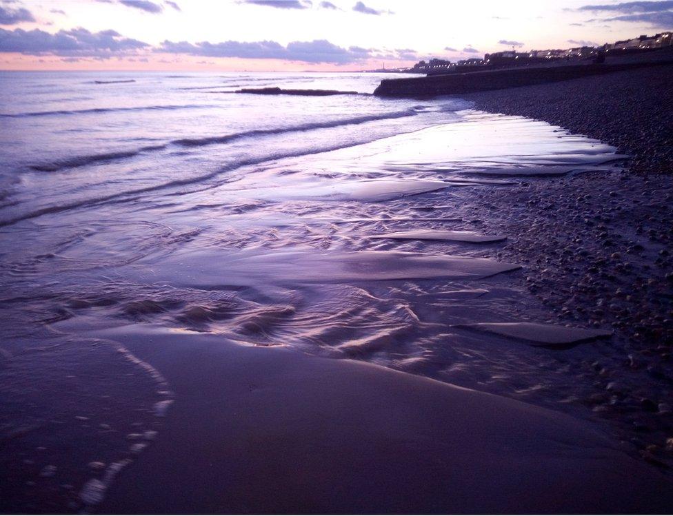 A purple sunset over a beach