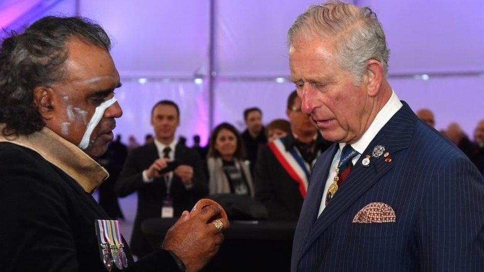 The Prince of Wales meets indigenous didgeridoo player David Dahwurr Hudson after an early morning memorial at the Villers-Bretonneux Memorial in France