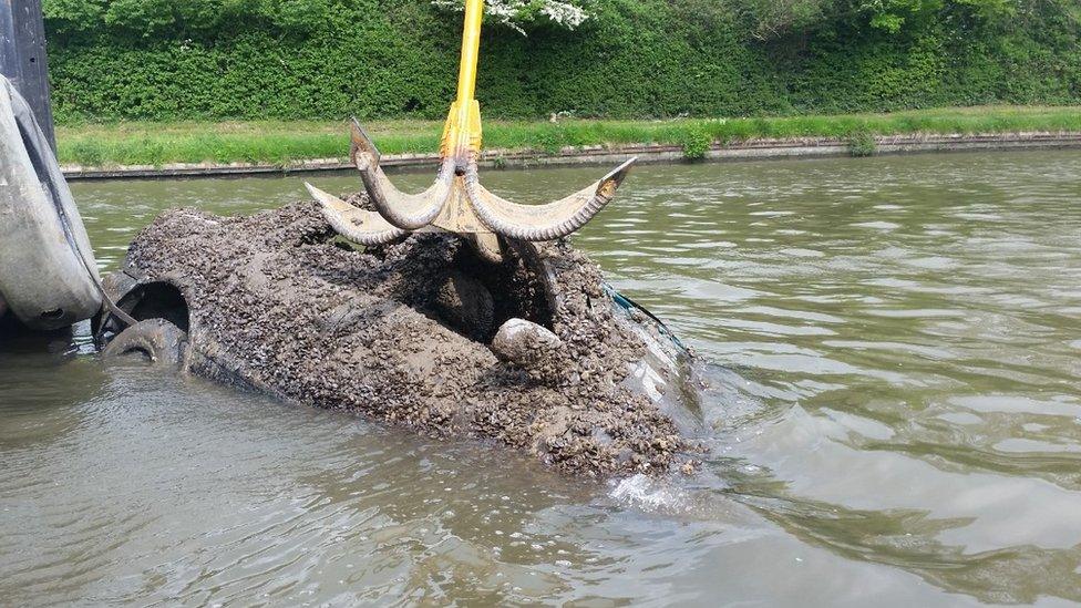 Car being pulled from canal