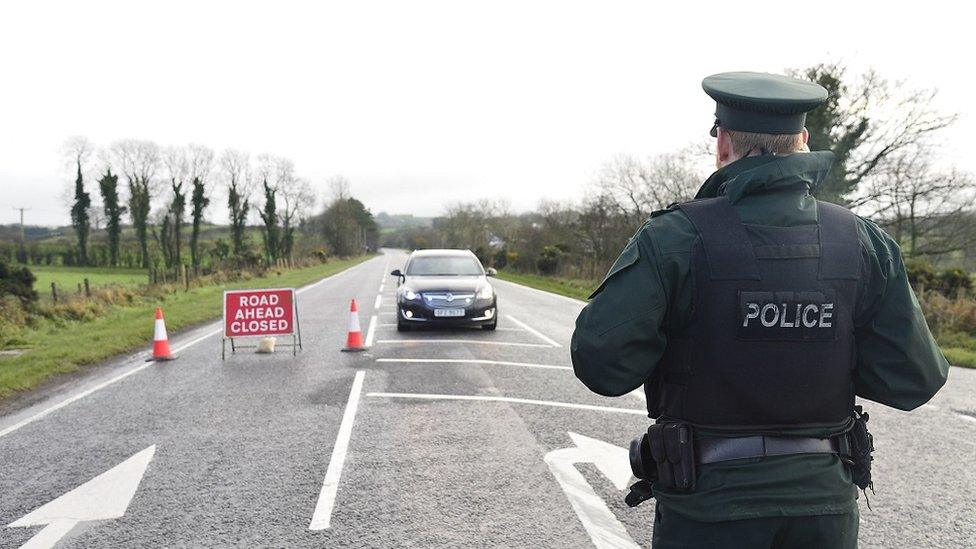 A police officer stands at a cordon at a cordon near the scene of the crash on the Omagh Road in Garvaghy