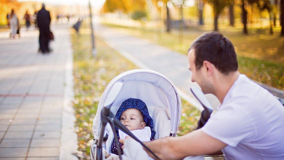 A father with his baby in a pram.