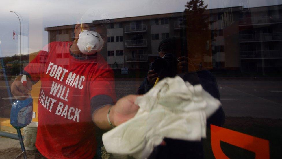 Restoration workers clean a downtown Fort McMurray shop on June 3, 2016 in Fort McMurray, Alberta