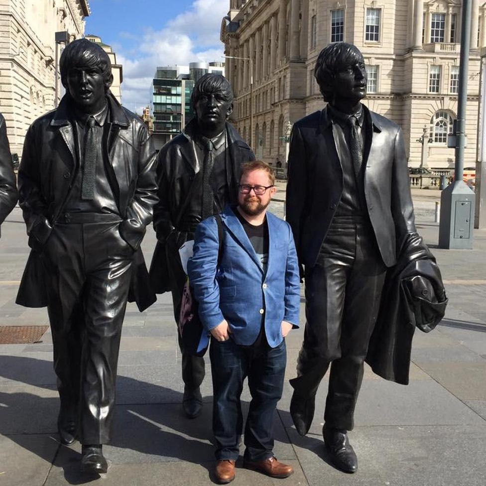 Allan in front of a statue of the Beatles