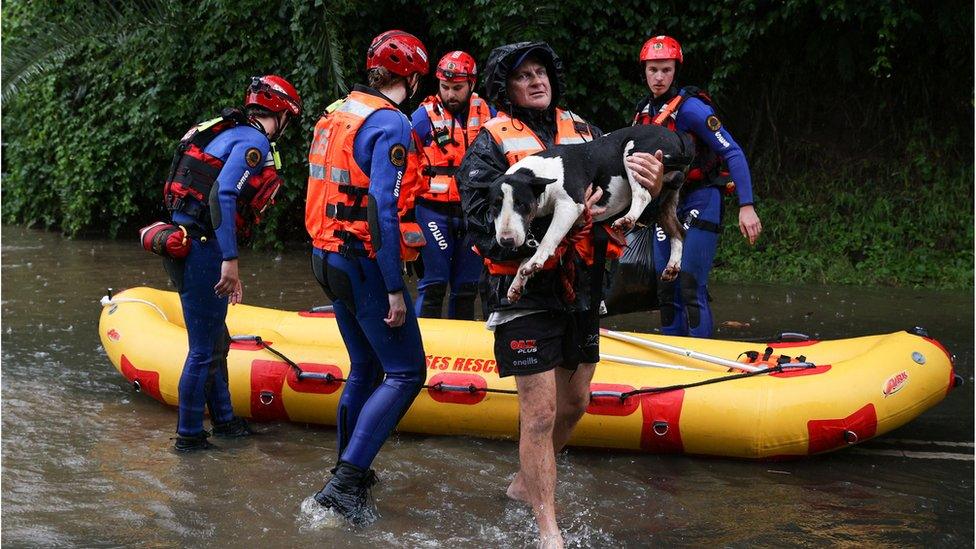 A local resident and his dog are brought to safety by a State Emergency Service rescue team in the midst of widespread flooding and severe weather across the state of New South Wales, in Sydney, Australia, March 21, 2021