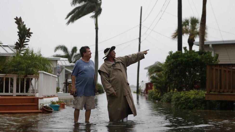 Residents of the Sandpiper Resort survey the rising water coming from the Gulf of Mexico into their neighbourhood as winds and storm surge associated with Tropical Storm Hermine impact the area on 1 September 2016 at in Holmes Beach, Florida.