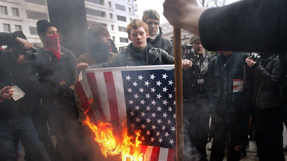 Anarchists burn the US flag after George W Bush's second-term inauguration in 2005