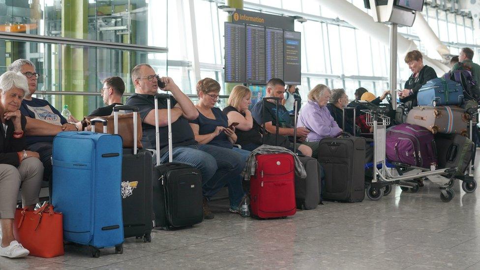 Passengers at Heathrow Airport wait for information on their delayed flights