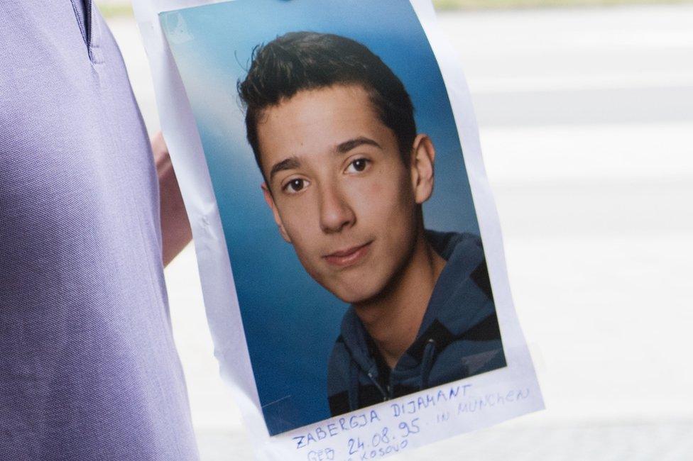 The father of Dijamant Zabergja clutches a photo of his son in Munich, 23 July