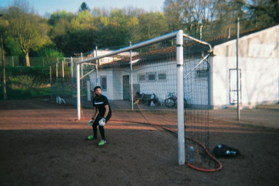 A goalkeeper stands in a goal