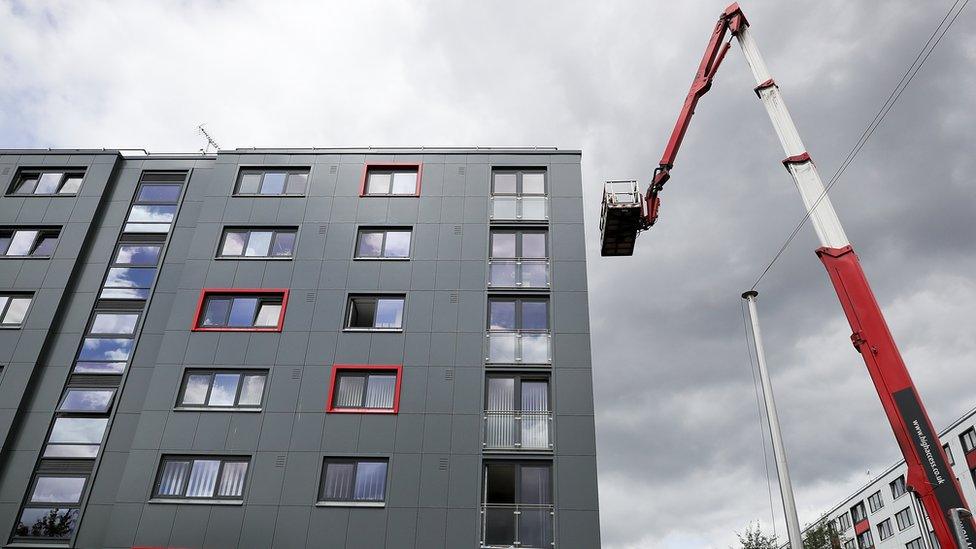 Cladding tiles being removed from a block in Salford for testing