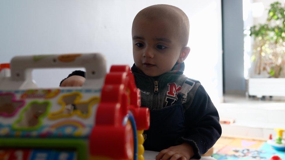 Pavlo plays with a musical toy at the Unicorn clinic in central Poland