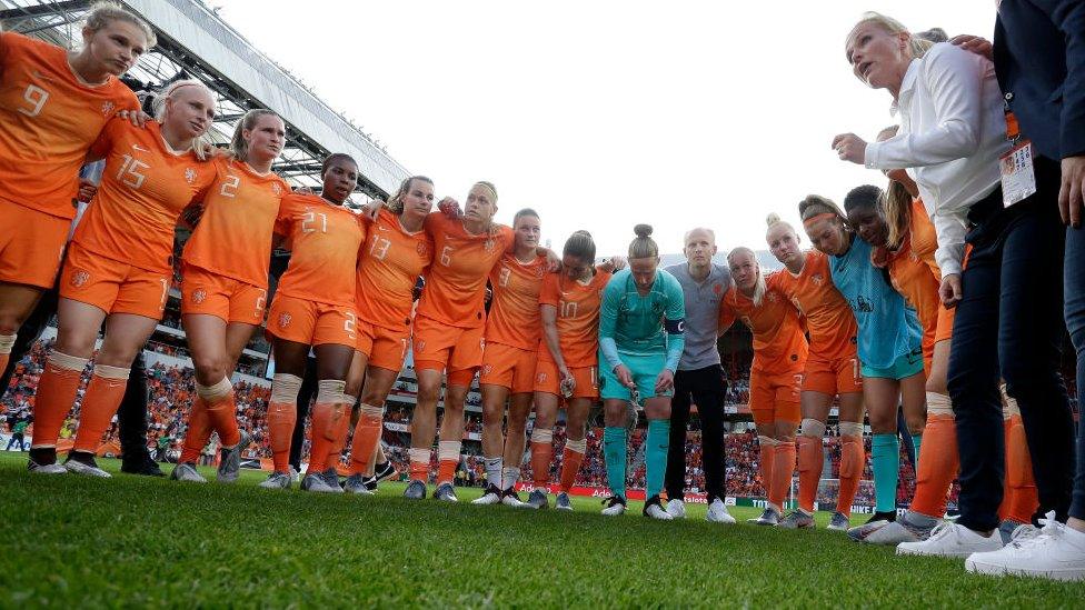 Sarina Wiegman talks to her players during a friendly match