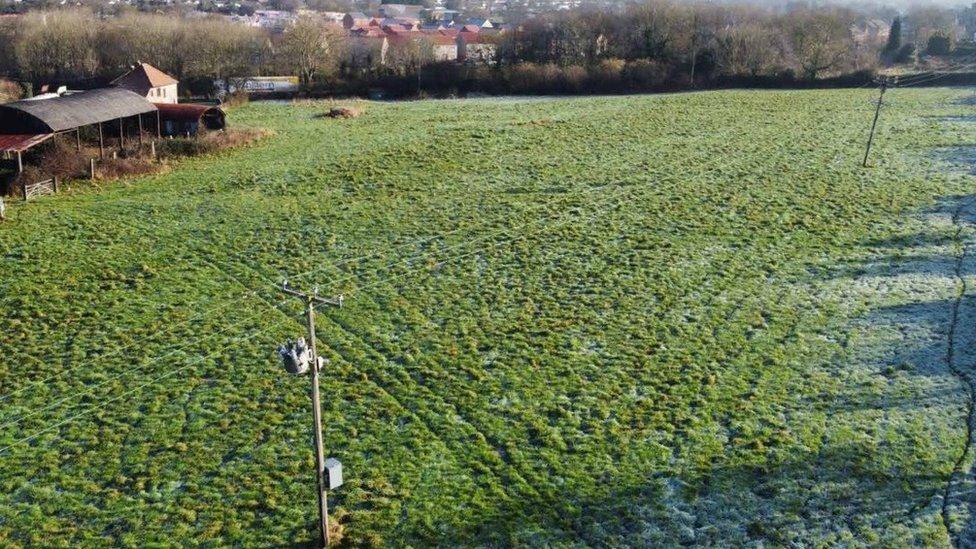 A field with a barn in