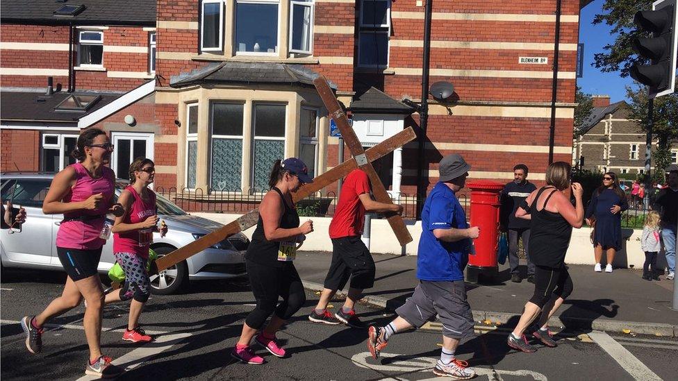 A runner carries a crucifix during the Cardiff Half Marathon