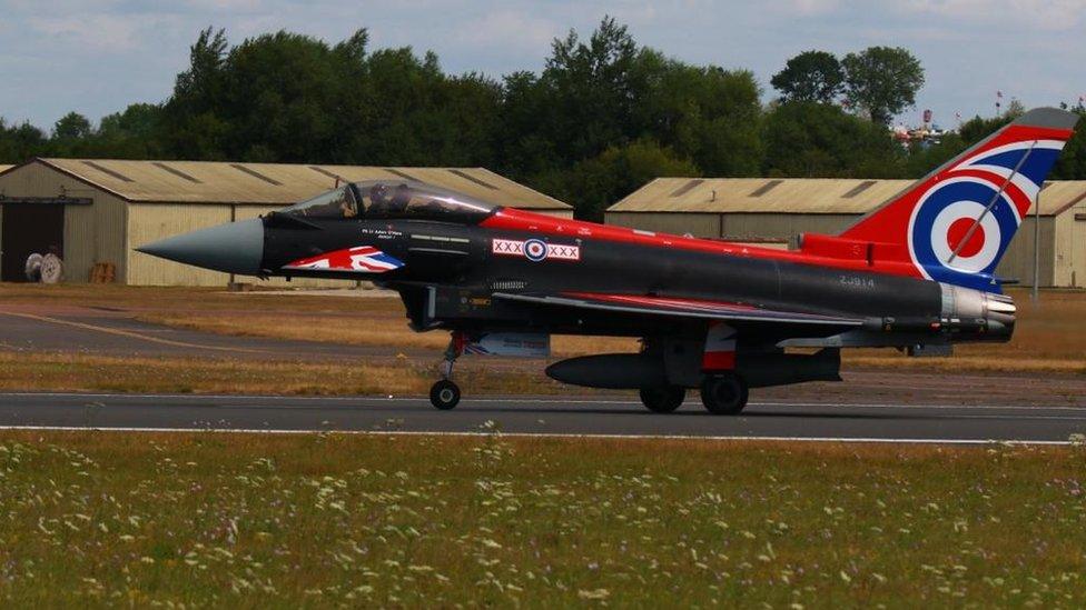 A plane with the colours of the Union flag parked in a field