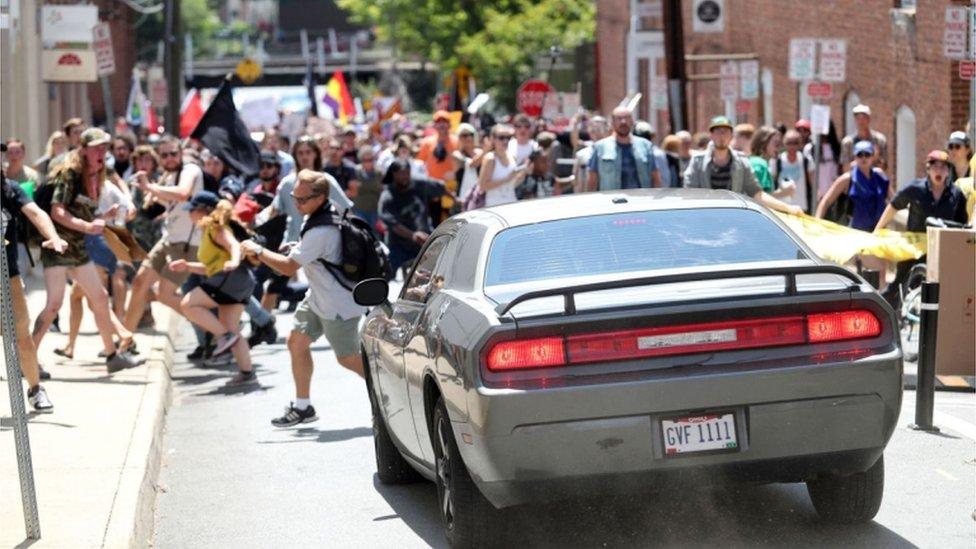 Car approaches group of protesters