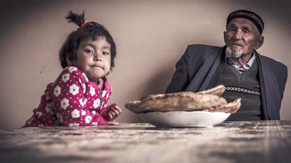 Seventy-eight-year-old former fishing captain Almas Tolvashev with his grand-daughter by Paul Ivan Harris