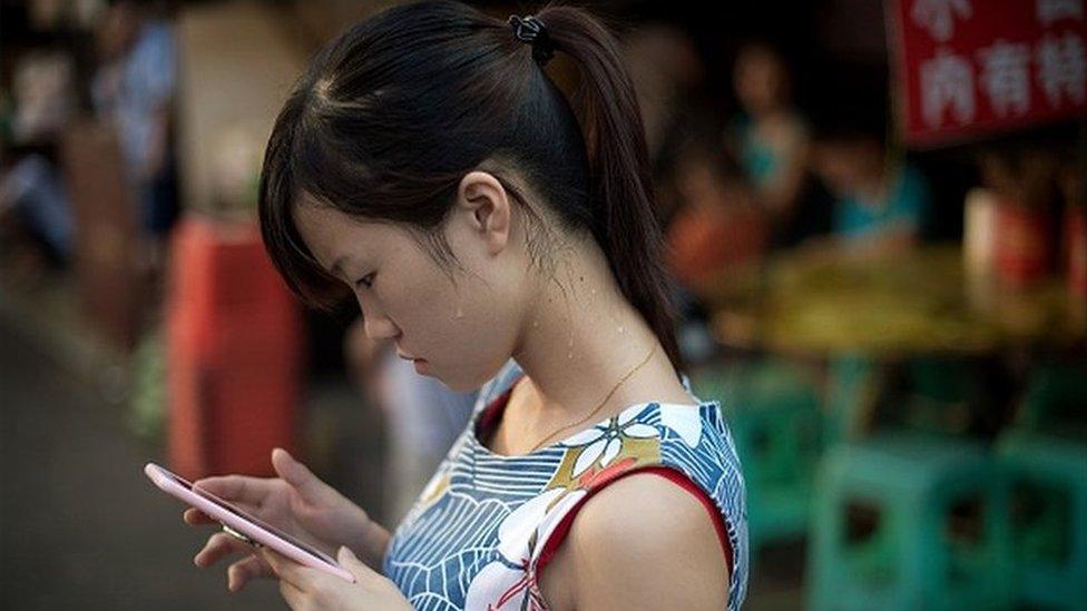 A woman checks her phone