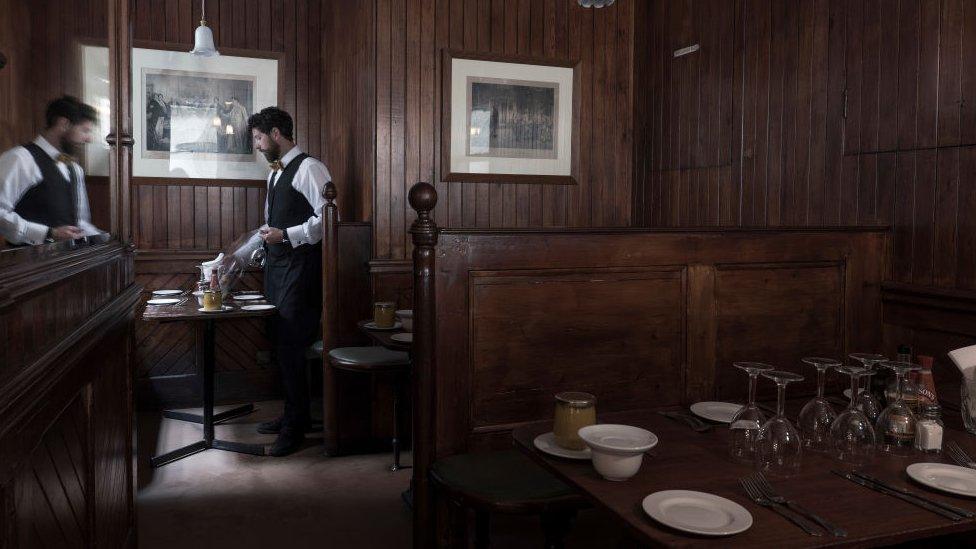 File photo showing a waiter setting tables inside the wood-panelled restaurant