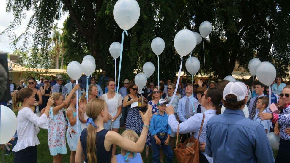 Mourners dressed in blue release