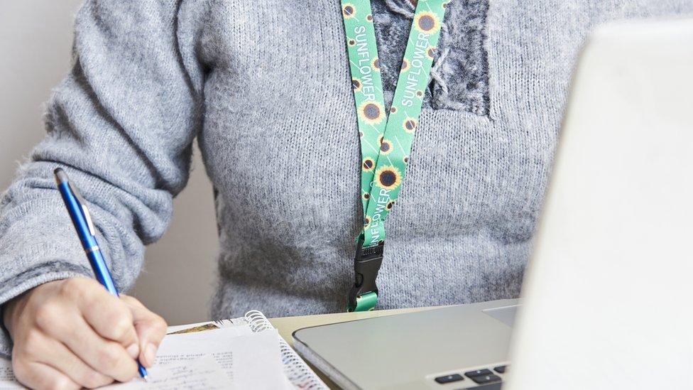 An adult wearing a Sunflower lanyard