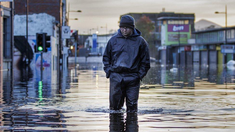 Man walks through flooded water in Downpatrick