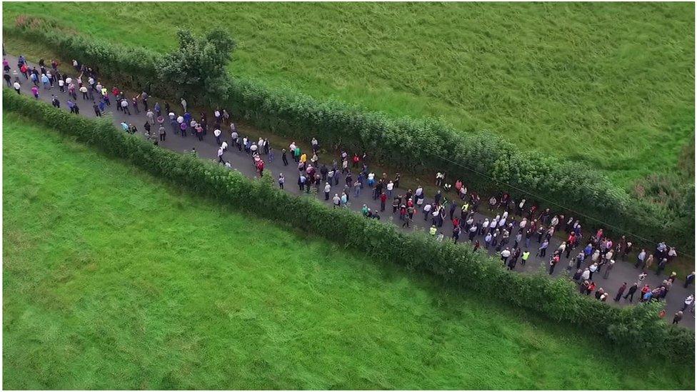 Large crowds gather on a road in County Armagh to watch the sport