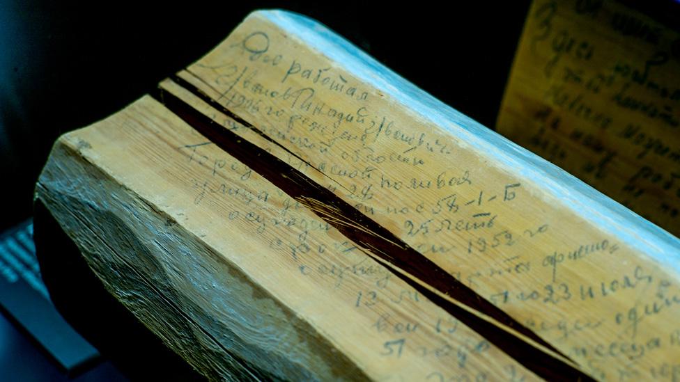 Log with prisoner's message scrawled on it