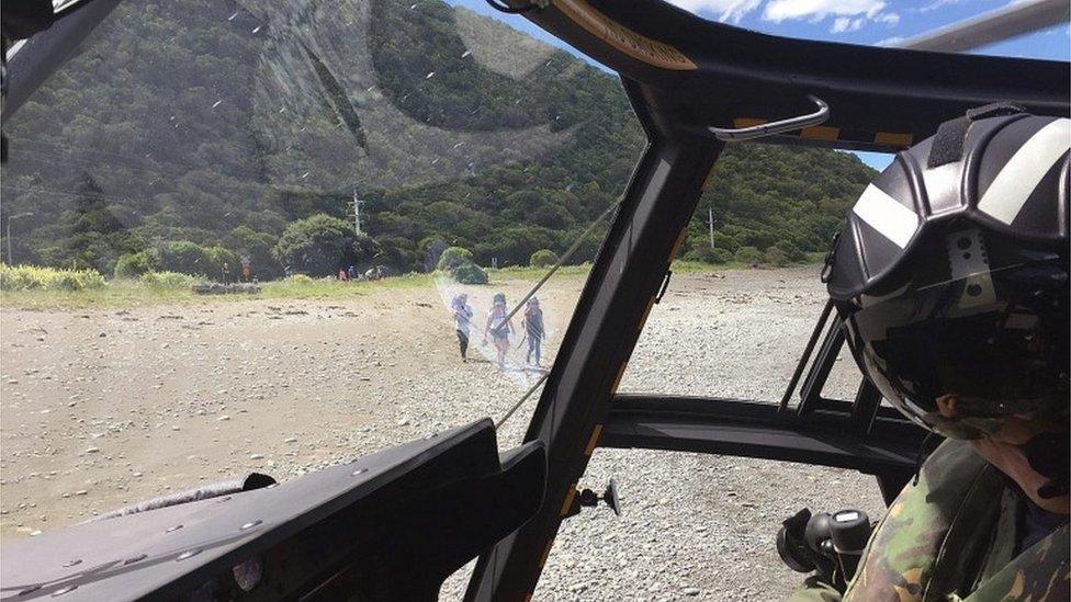 Tourists head to an evacuation helicopter in Kaikoura, New Zealand (15 Nov 2016)