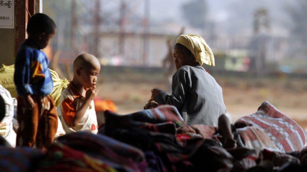 Refugees from northern Myanmar sit on a pile of blankets inside a monastery which has been set up as temporary refugee camp in KyaukMe, northern Shan State, Myanmar, 21 February 2016