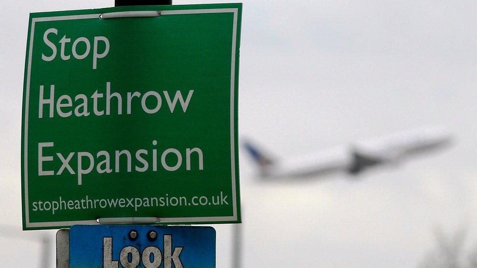 A anti Heathrow expansion sign is displayed near to Heathrow airport as a plane takes off