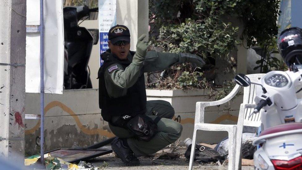 A Thai policeman helps an injured victim following a bomb attack in Hua Hin, Thailand, 12 August 2016.