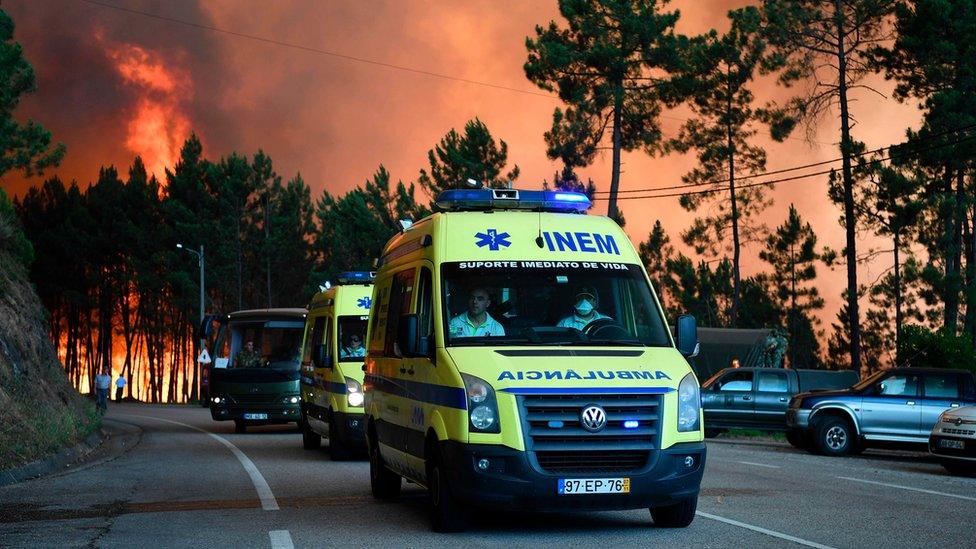 Ambulances lead the way during the evacuation of Picha, as a wildfire approaches the village near Pedrogao Grande on June 20, 2017