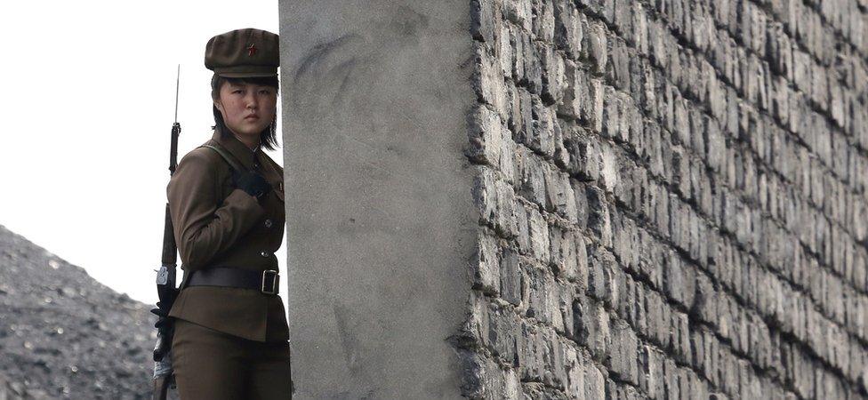 A North Korea woman soldier patrols the bank of the Yalu River which separates the North Korean town of Sinuiju from the Chinese border town of Dandong