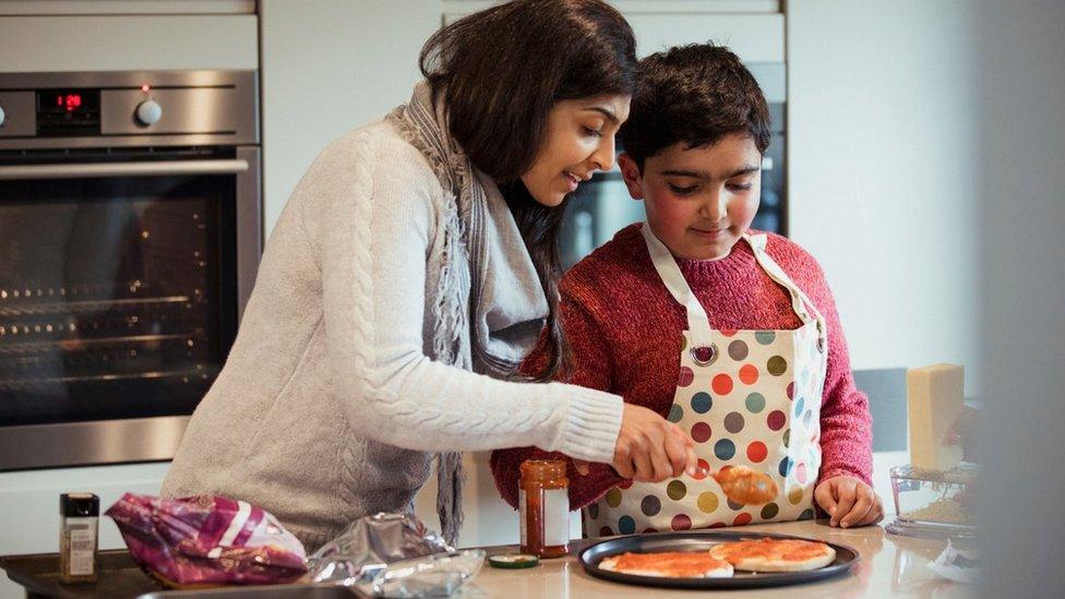 Generic image of an autistic south Asian/Indian boy with his mum making pizza