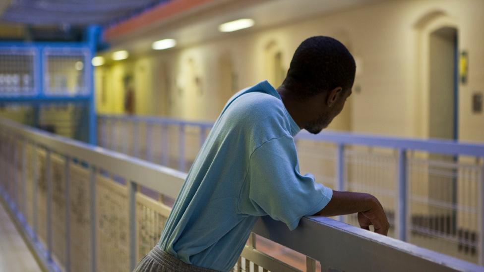 An inmate looks over D wing from the middle landing at HMP Wandsworth