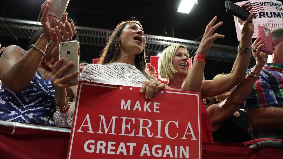 Trump supporters hold up placards saying "Mark America Great Again2 at a rally in Virginia, 20 August