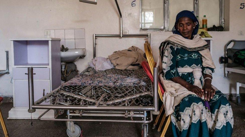 A woman sits next to a looted bed at Wukro General Hosptial, allegedly by Eritrean forces, in the city of Wukro, north of Mekele, on February 28, 2021.