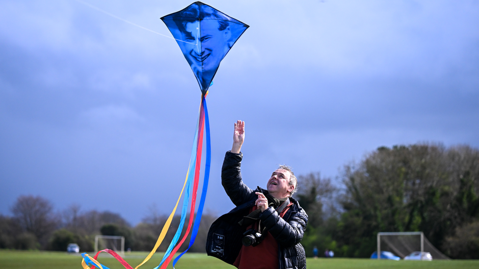 Man letting kite fly in the wind