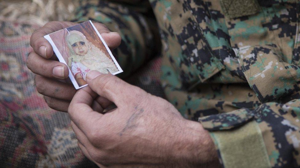 Fatima’s father, Samir, holding a photo of her