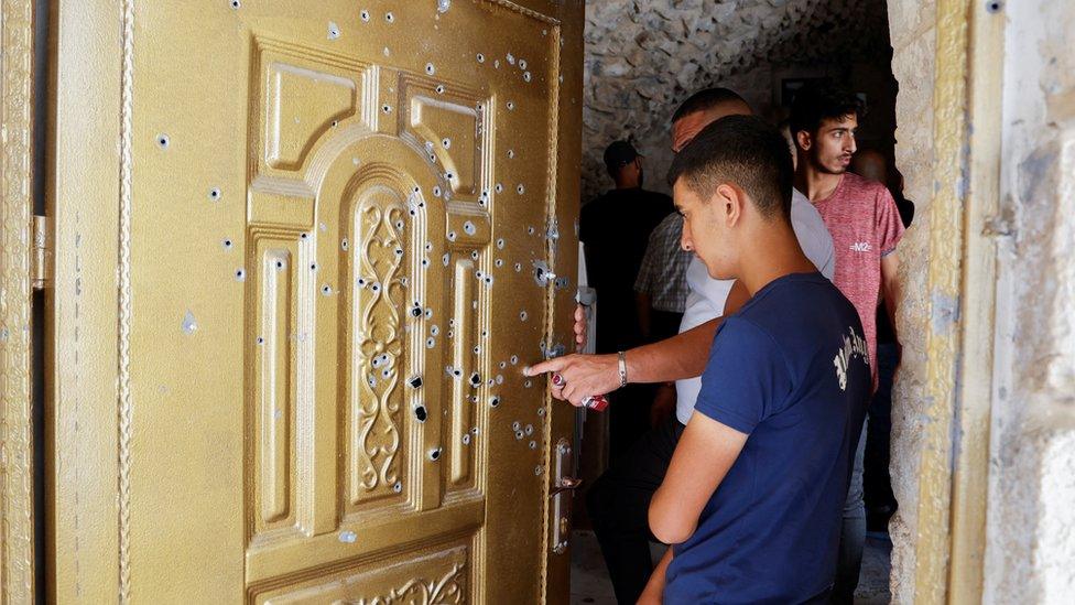 People check damage in a house where two Palestinians were killed during an Israeli raid in Nablus