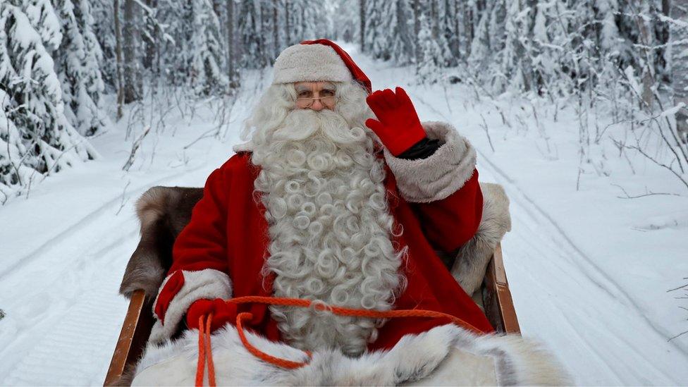 A man dressed as Santa Claus in the snow