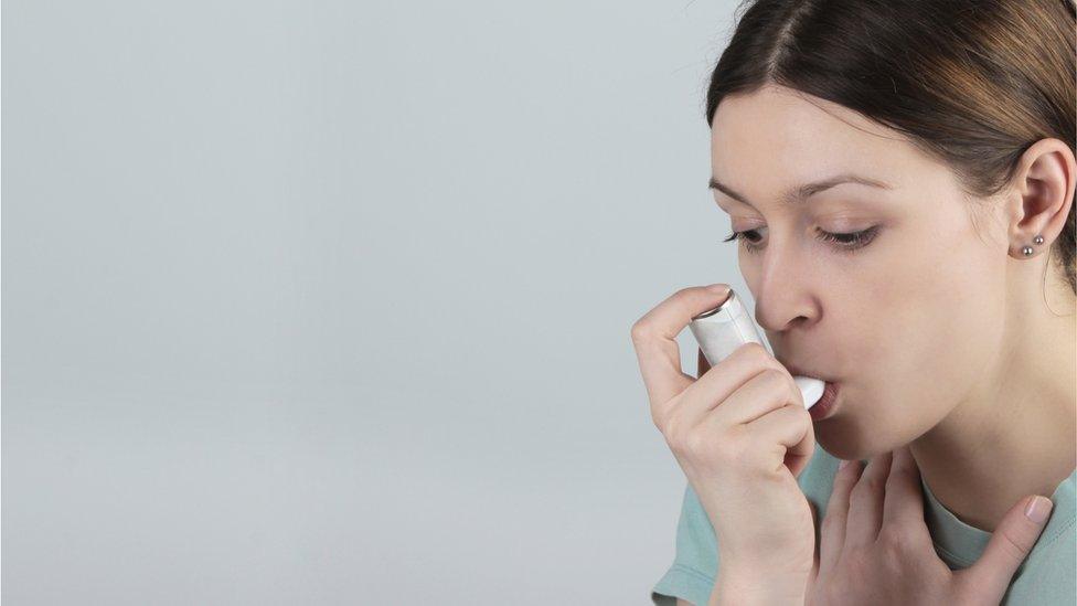 Woman using asthma inhaler