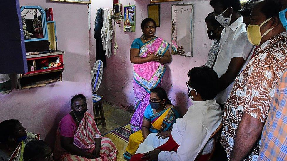 A church priest (C bottom) consoles family members of the victims.