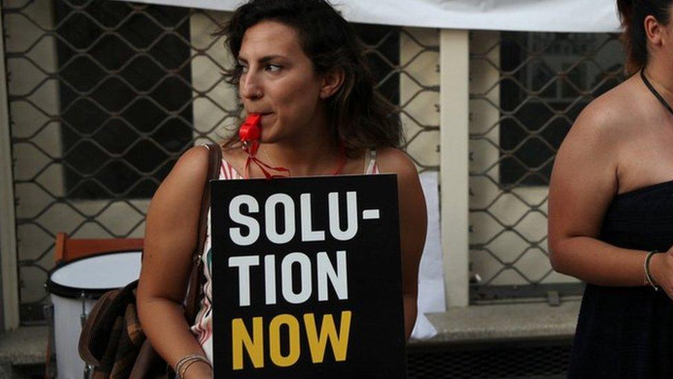 Women with signs saying "unite Cyprus now and "Solution Now"