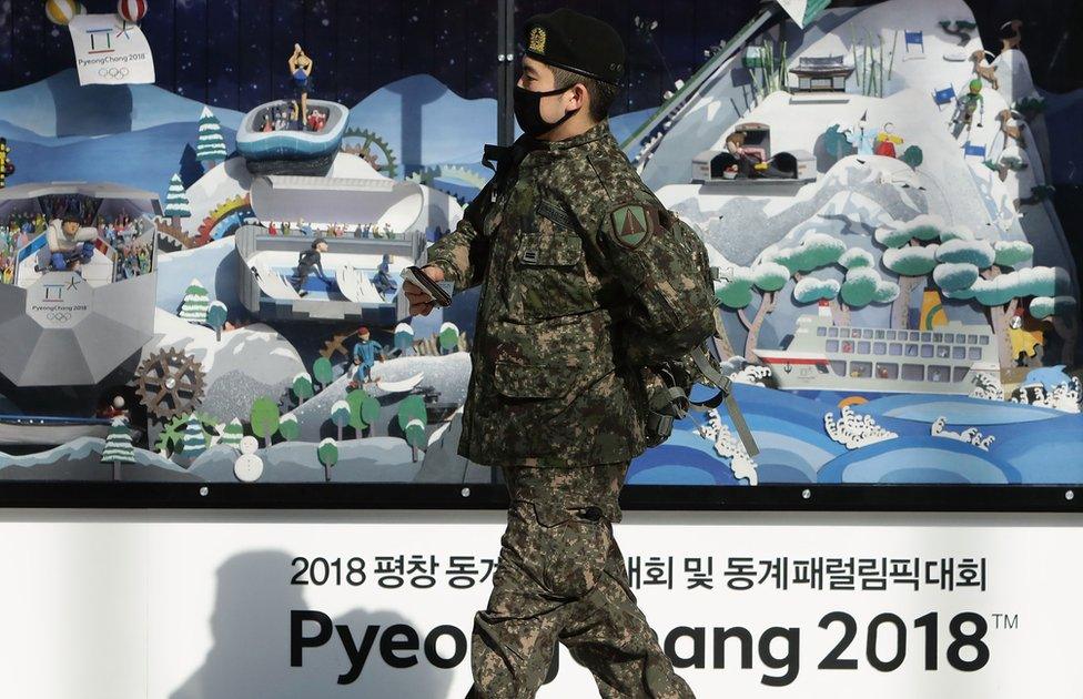 A South Korean soldier walks past the 2018 Pyeongchang Winter Olympic and Paralympic Games PR booth, 5 January 2018