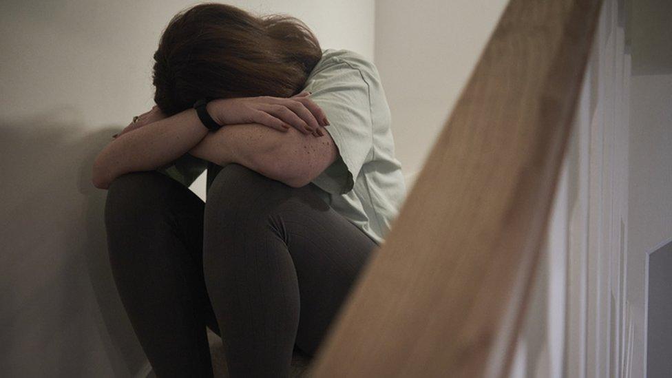 A distressed woman sitting on the stairs