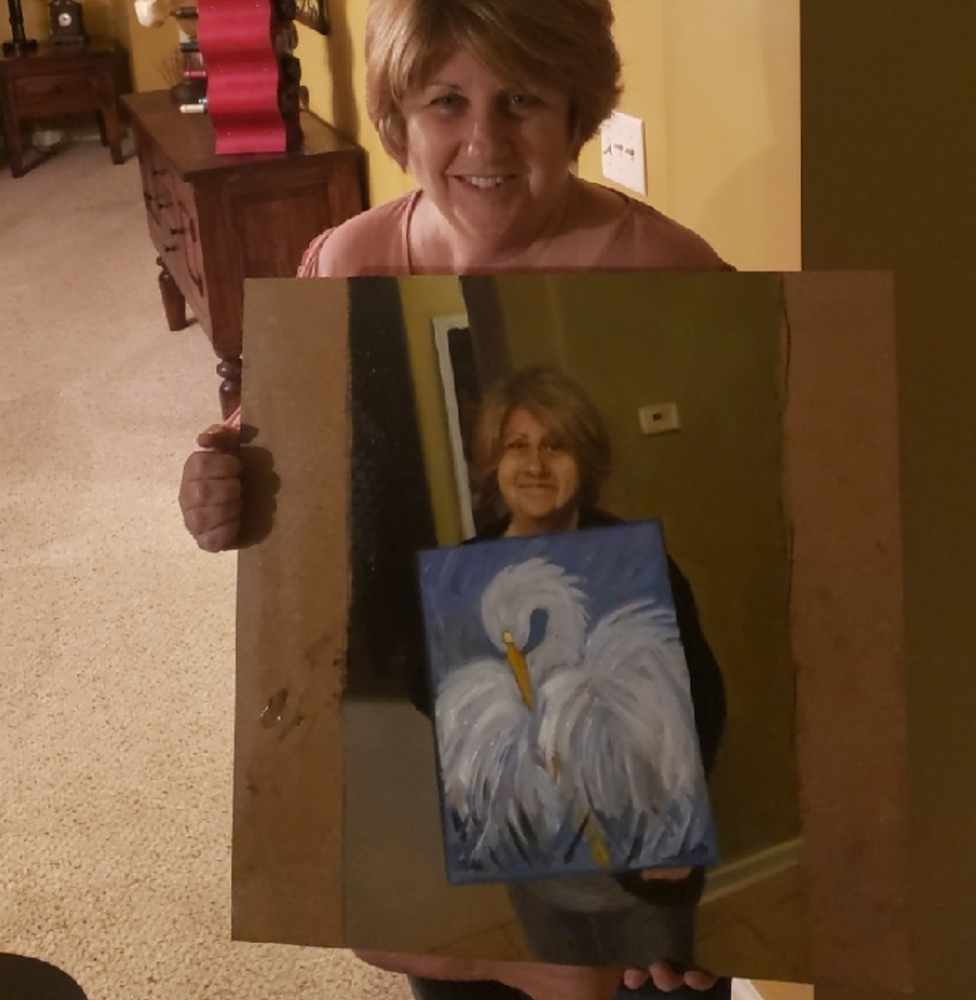 Cindi Decker (left) holds Kristoffer Zetterstran's (right) painting of her holding her bird painting